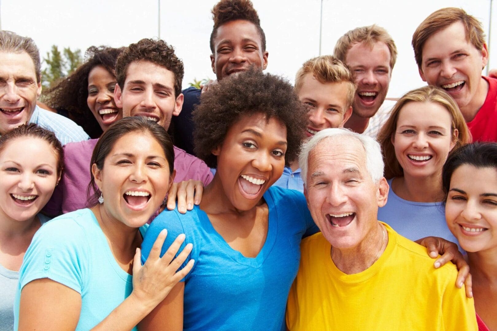 A group of people both young and old smiling for a picture